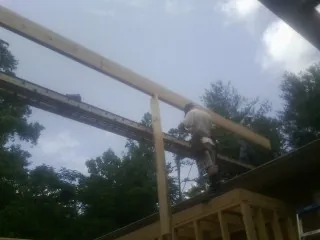 Carpenter setting a ridge beam over a new addition frame — Ice Dam Removal by Roofing Brothers in Poseyville