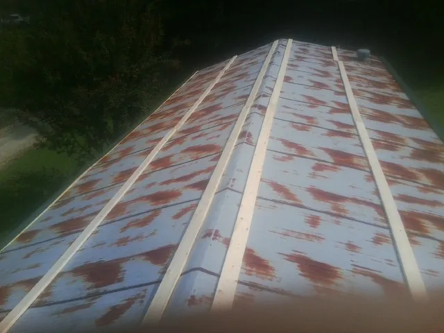 Rusted metal roof panels with new wood purlins before replacement — Storm Damage Roof Repair in Poseyville by Roofing Brothers