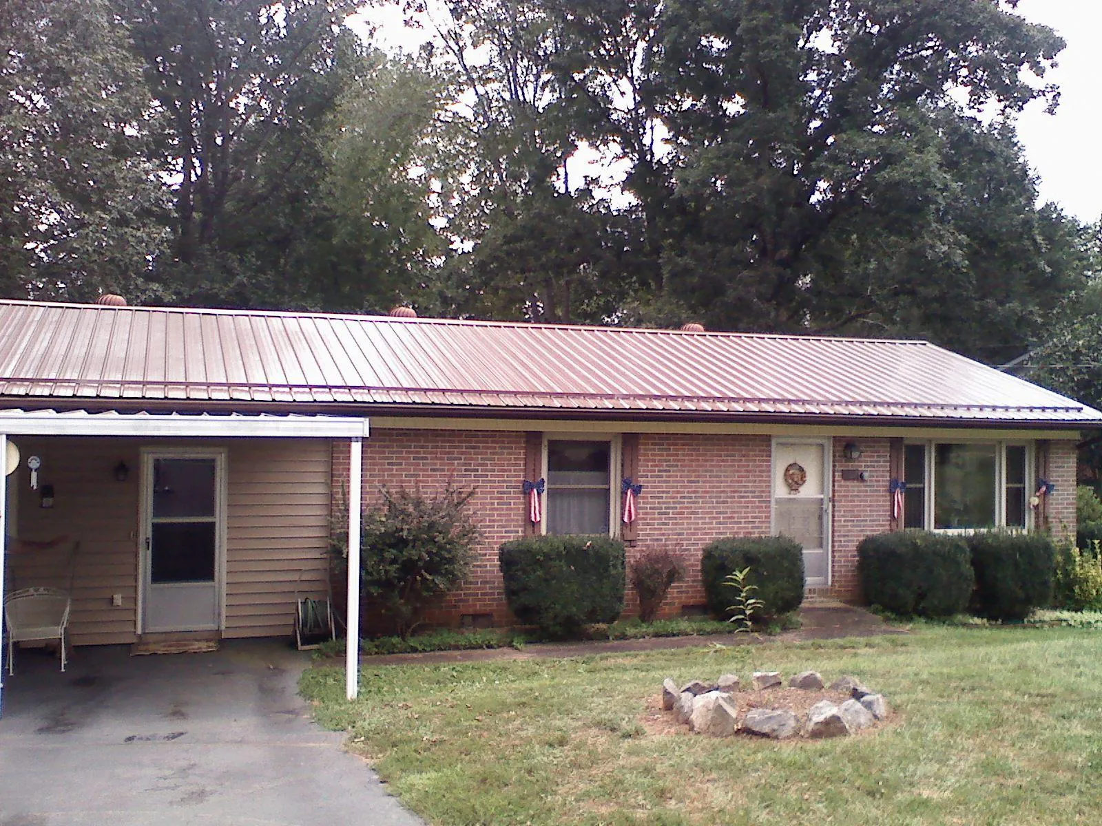 Bronze metal roof and carport on a brick ranch home — Roof Repair work by our crew in Poseyville