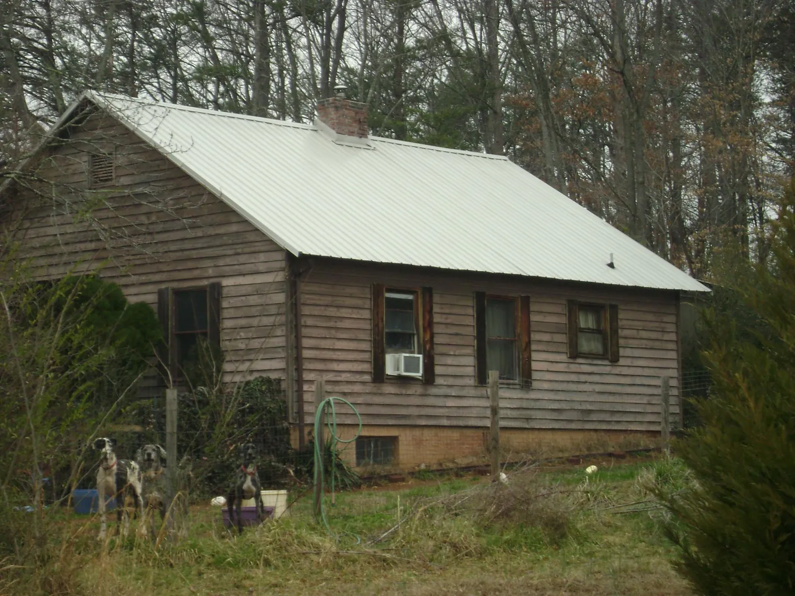 White metal roof on an old wood sided farmhouse, from a Metal Roof Installation job in Poseyville